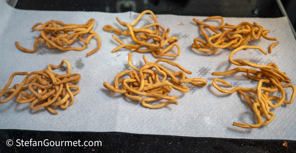 Crispy fried noodles arranged on a paper towel, typical for serving with Khao Soi.