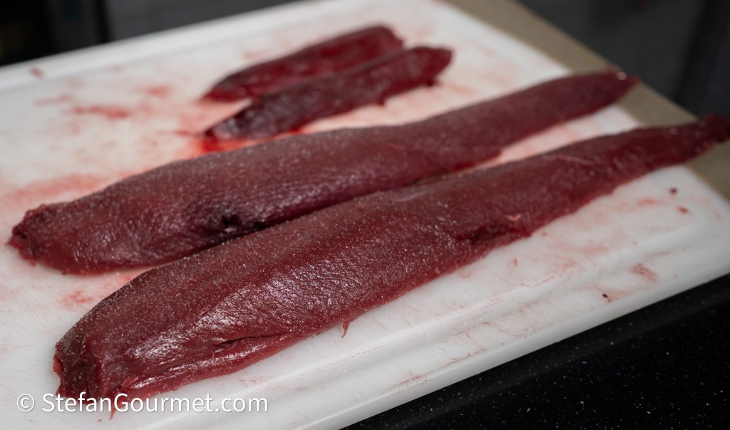 Raw hare fillets displayed on a cutting board, highlighting their rich red color and smooth texture.