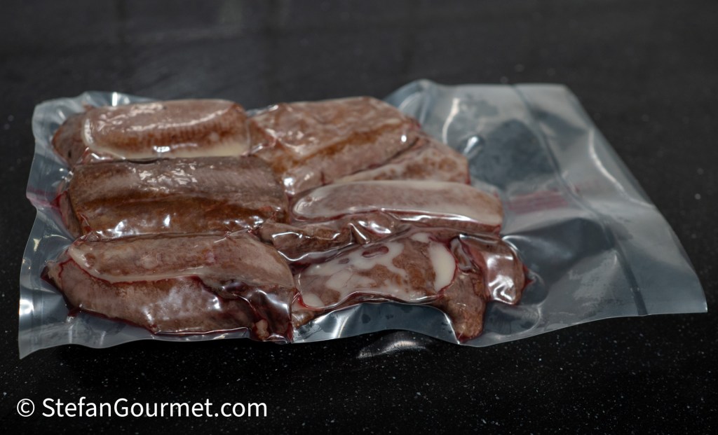 Vacuum-sealed hare fillets ready for sous-vide cooking on a black countertop.