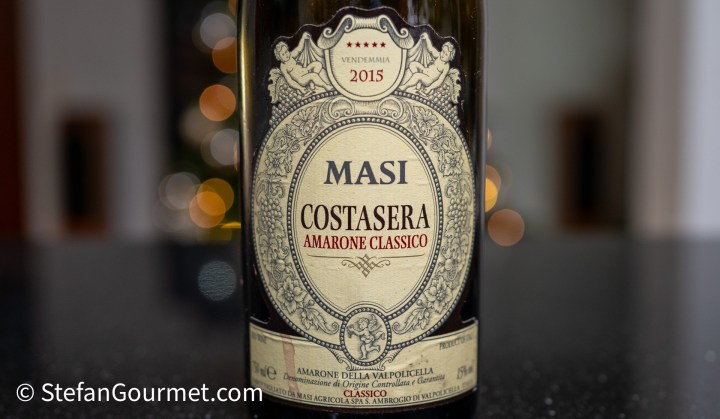 A bottle of Masi Costasera Amarone Classico 2015 wine with a decorative label, featuring intricate designs and a vintage mark.