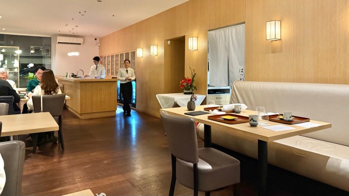 Interior view of Hatsune restaurant in Amsterdam, featuring minimalist decor, wooden accents, and high-end dining setup with tables and seating.