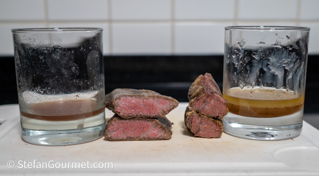 Two glasses with drinks, one containing a clearer liquid and the other a darker one, beside slices of medium-rare beef tenderloin on a cutting board.
