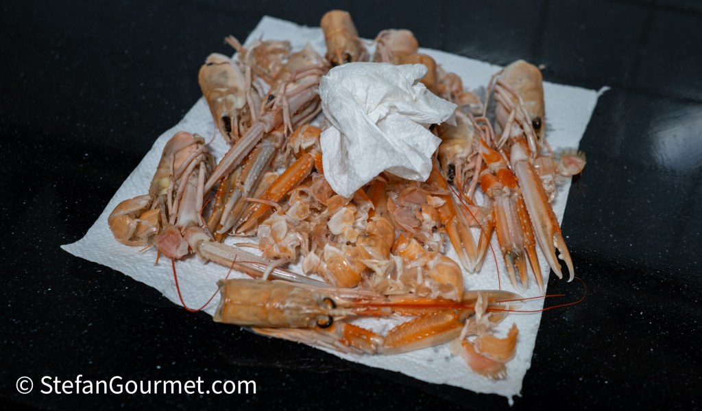 A pile of peeled shrimp and shell remnants on a paper towel.