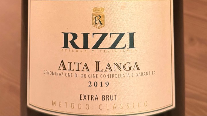 Close-up of a wine label featuring Rizzi Alta Langa Extra Brut 2019, showcasing the wine's name, classification, and details.