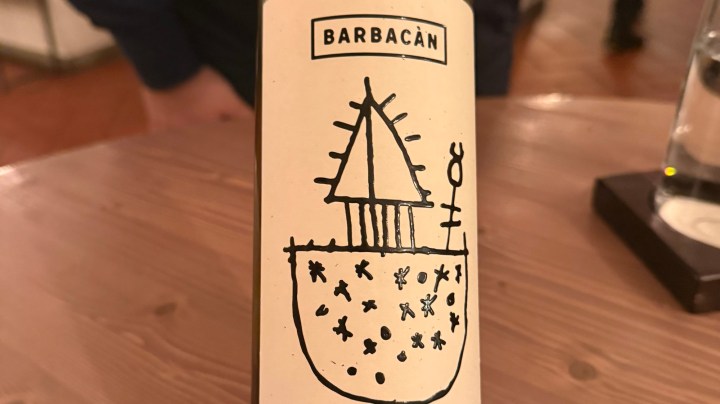 A close-up image of a wine bottle label featuring a hand-drawn sketch of a sailboat and abstract shapes, with the text 'BARBACÁN' at the top.