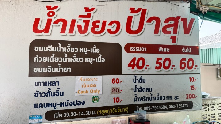 Menu board displaying prices for various dishes, including soups and side items, with options for special and standard dishes in Thai language.
