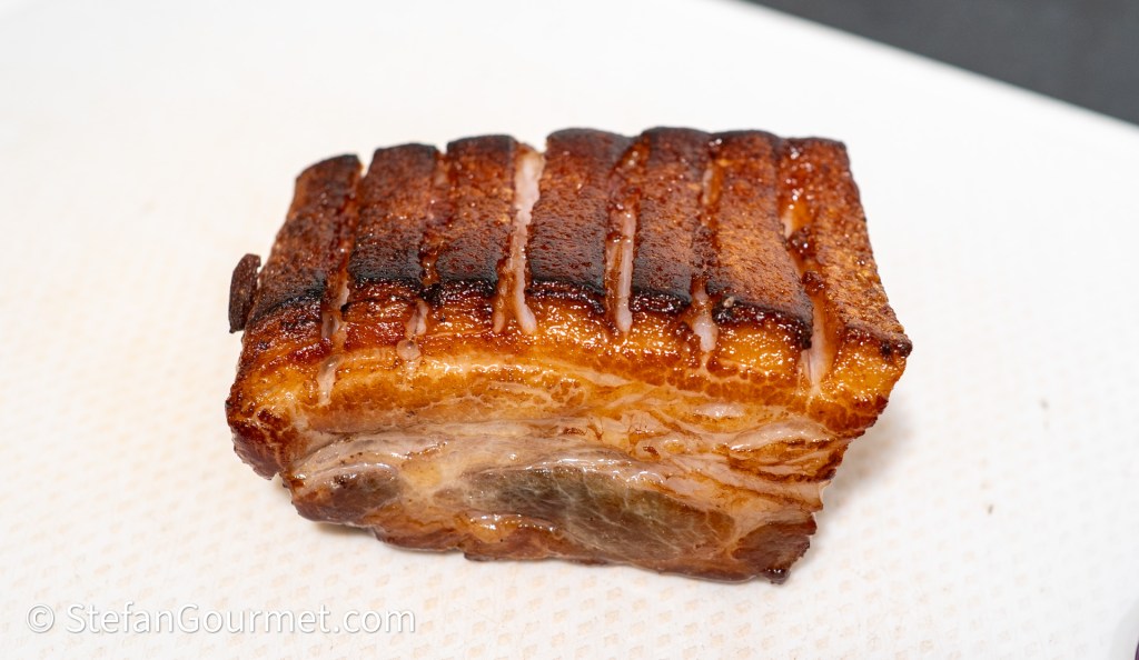 A perfectly cooked piece of pork belly with crisp skin and visible layers of fat and meat.