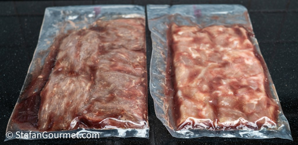 Two vacuum-sealed packages of meat, one on the left with a darker color and the other on the right with a lighter color, placed on a dark surface.