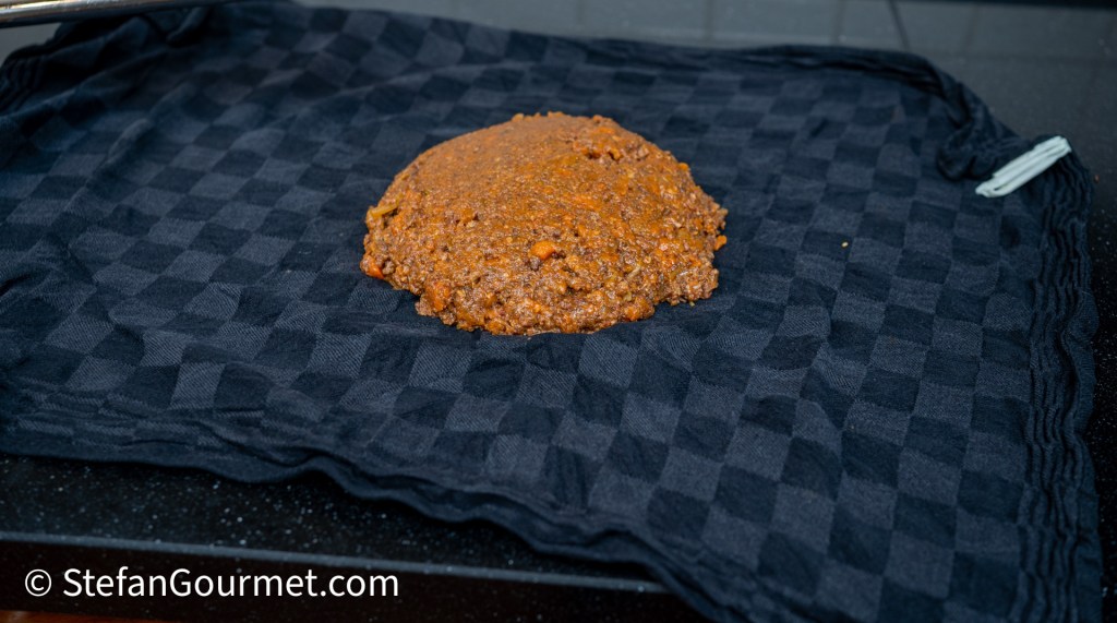 Dough resting on a black checkered cloth.