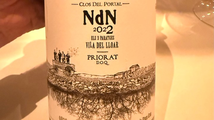 A close-up image of a wine bottle label featuring 'Clos Del Portal NdN 2022', with illustrations of a wagon and people, and text indicating 'Vila del Lloar' and 'Priorat D.O.Q.'